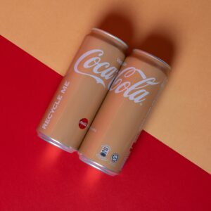 Studio shot of Vanilla Coca-Cola cans on vibrant red and yellow background.